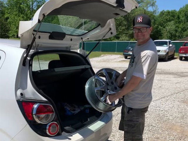 Craig (sales) loading a wheel into a trunk