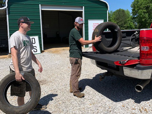 Britt (parts puller/dismantler) and David (inventory and parts manager) moving tires